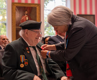 Governor General Mary Simon pins a poppy on a veteran