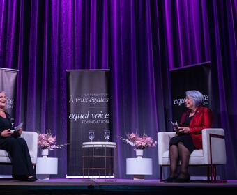 Governor General Mary Simon sits on a stage talking to Lisa LaFlamme