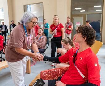 Governor General Mary Simon shaking an athlete's hand.