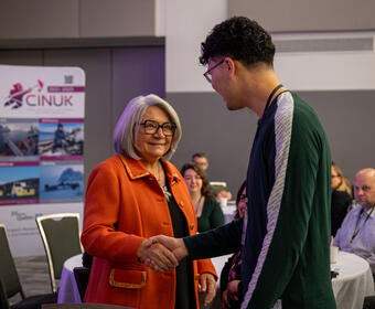 La gouverneure générale Mary Simon serrant la main d'une personne.