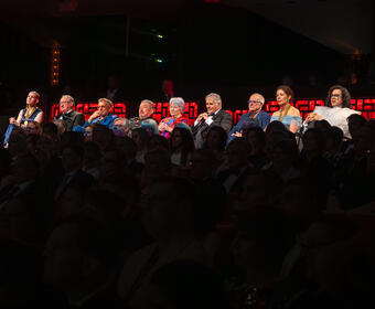 A group of laureates at the Governor General's Performing Arts Awards gala with the Governor General and Whit Fraser. They are seated in the balcony.