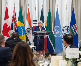 Governor General Mary Simon standing at a podium at a G7 event.