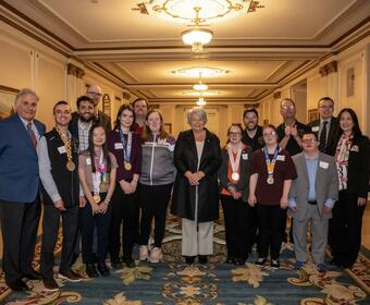 Governor General Mary Simon posing with a group of people involved in the Special Olympics. Several people are wearing medals.