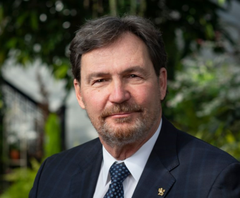 L'administrateur est assis à l'extérieur, il est souriant.souriant à l'appareil photo. 