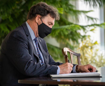 L'Administrateur assis à un bureau, signant un document.